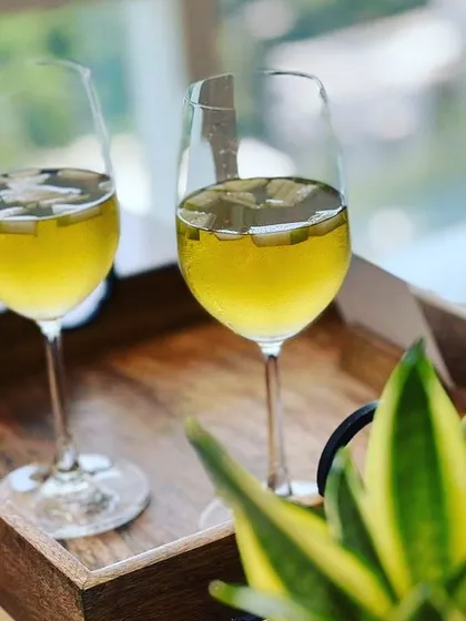 A refreshing Green Apple Iced Tea, served in elegant wine glasses, a perfect antidote to the Mumbai heat.