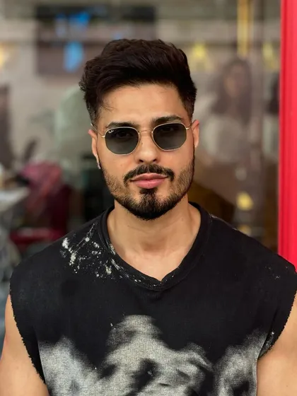 A front-on view of this stylish fade and beard combination. The haircut is designed to complement the client's face shape and personal style.