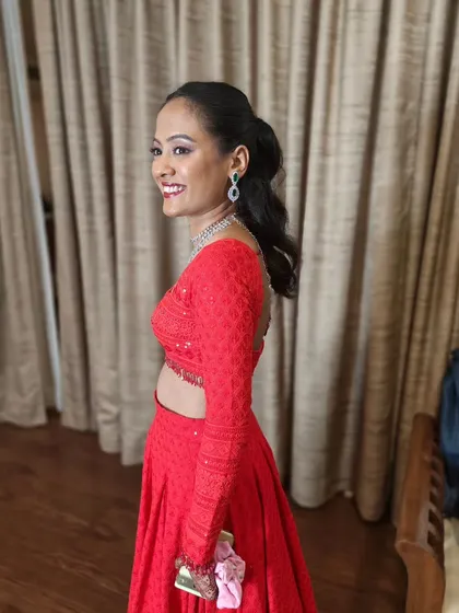 A modern Sangeet look featuring a sleek high ponytail and a bold red lip. This style is chic, comfortable, and perfect for a bride who wants to dance the night away.