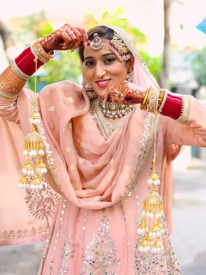 This bride's smile is infectious. Her makeup is fresh and elegant, highlighting her features without overpowering her delicate pastel outfit and jewelry.