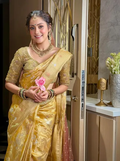 A sweet and serene portrait of the bride holding a lotus flower. Her makeup is soft and glowing, adding to the overall feeling of grace and purity.