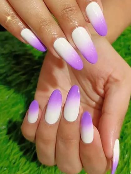 A vibrant purple-to-white ombre on long almond nails, perfect for making a colorful statement.