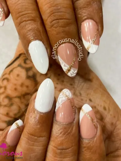 A beautiful fusion of classic and contemporary for a festive occasion. This design combines clean, solid white nails with nude-base nails featuring a delicate gold glitter pattern. The look is perfectly coordinated with the client's henna.