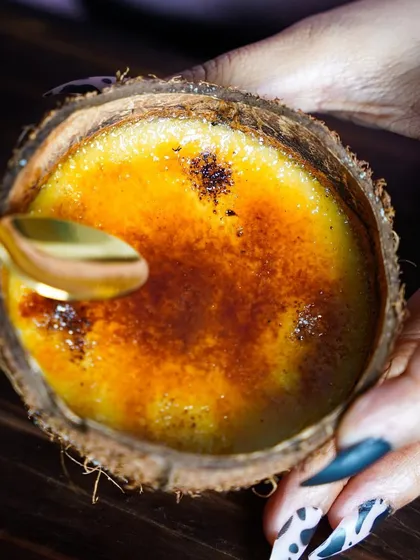 The perfect crack of the caramelized sugar on our Crème Caramel. It's a moment of pure dessert bliss.