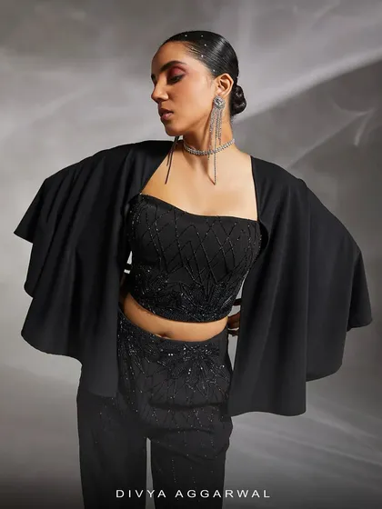 A close-up of the Ezra co-ord set, highlighting the hand-embellished top and the dramatic, detachable cape sleeves.