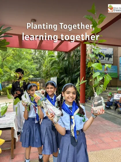 Planting together, learning together. Smiling students hold up saplings in recycled newspaper pots, ready to be planted, showcasing a sustainable approach to nursery management.