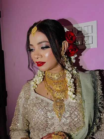 A side profile of the Nikaah bride, showing off the beautiful floral hair arrangement and the glowing skin finish. The look is both traditional and glamorous.