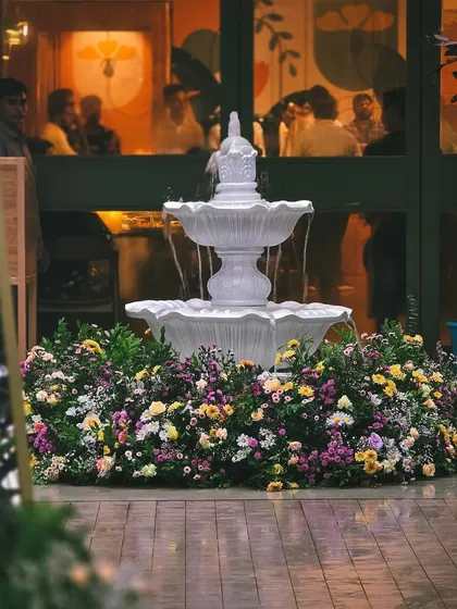 A stunning white fountain surrounded by a bed of colorful, fresh flowers. This was the centerpiece of the baby shower, adding a touch of classic garden party elegance.