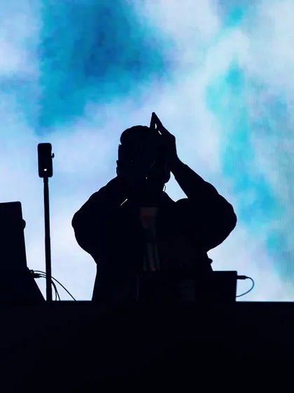 A silhouette against a cloudy blue screen. This artistic shot captures the larger-than-life feeling of being on stage.