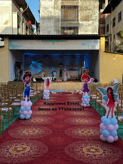 This photo shows the entrance aisle for a large naming ceremony held in a community hall. I lined the red carpet with character cutouts on balloon pillars to build excitement as guests walk towards the main stage.