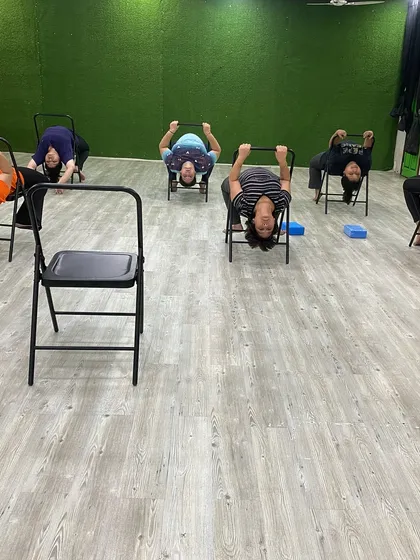 Our members practicing a supported backbend, which helps improve spinal flexibility and opens the chest.