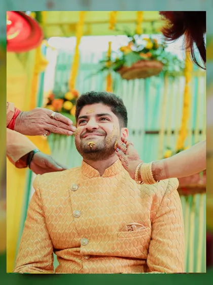 A portrait of the groom during his Haldi ceremony. We capture his happy and slightly mischievous expression as his family applies the turmeric paste.