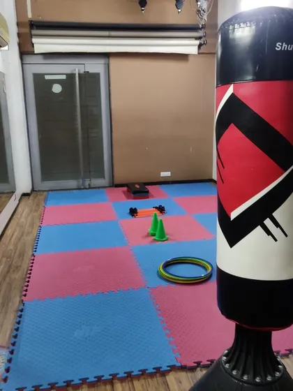 This is my training academy, a safe and fully equipped space for learning. We have matted floors for safety during drills and all the necessary equipment, like this punching bag, for effective strength and conditioning.