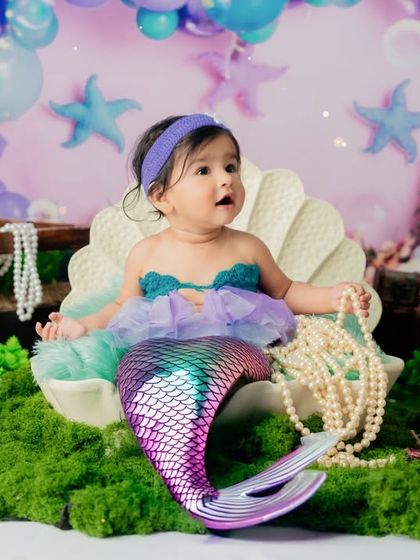 Our little mermaid is now sitting up. This milestone session continues the underwater theme with a beautiful backdrop of balloons and pearls.