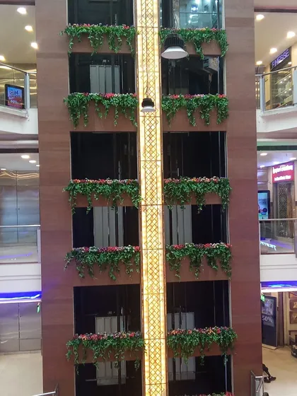 A closer look at the artificial flower boxes on the mall elevator shaft.