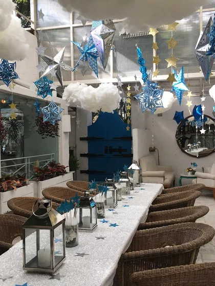 A beautiful star-themed party setup in a sunlit room. The ceiling was filled with hanging stars and clouds, creating a magical sky for the celebration.