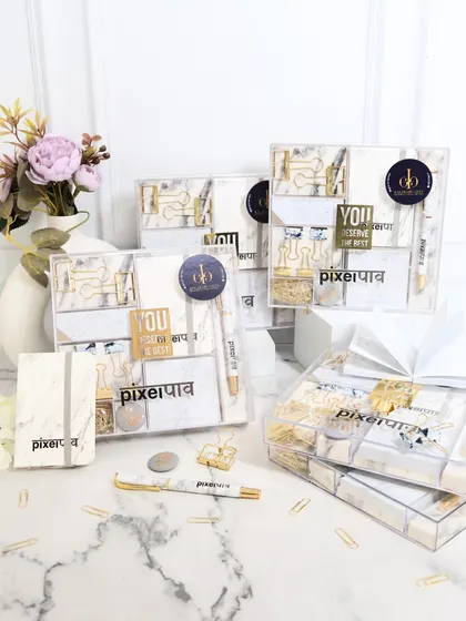 My marble and gold stationery set is designed for a sophisticated and aesthetic workspace. This set includes a clear acrylic organizer filled with marble-print notepads, a matching pen, and gold-finished paper clips, making it an ideal gift for employee appreciation or client thank-yous.