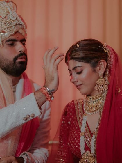 The groom applies the sindoor, marking the completion of the wedding ceremony. A moment of profound significance.