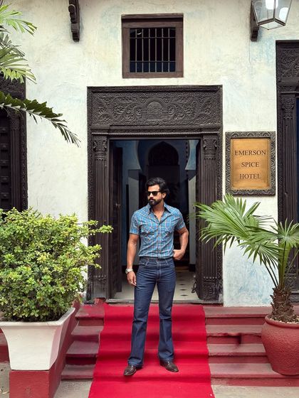 The full look, featuring our blue check shirt and flared jeans, makes a grand entrance on a red carpet, proving that casual wear can be glamorous.