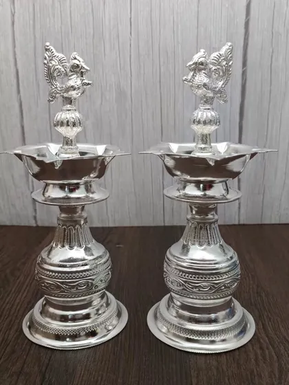 Another design of the German silver Nakashi deepam pair, with a slightly different base and peacock carving.