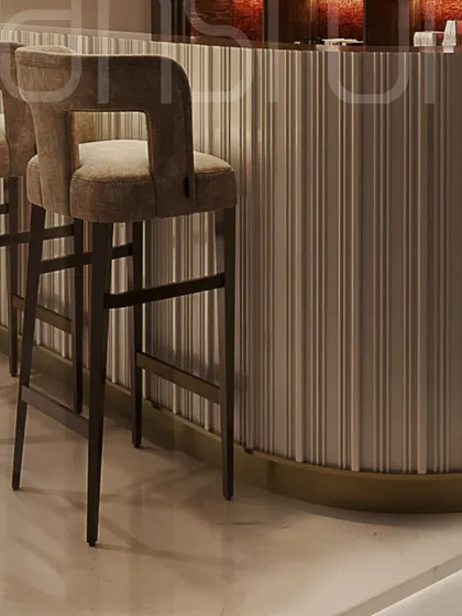 A close-up on the bespoke bar stools, highlighting their refined shape and luxurious fabric. Every piece of furniture is chosen to contribute to the overall symphony of refinement.