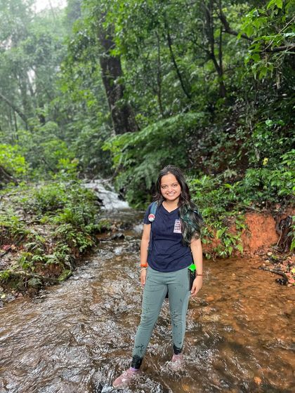 A trekker wading through a stream on the Kodachadri trail.