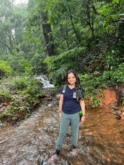 A trekker wading through a stream on the Kodachadri trail.