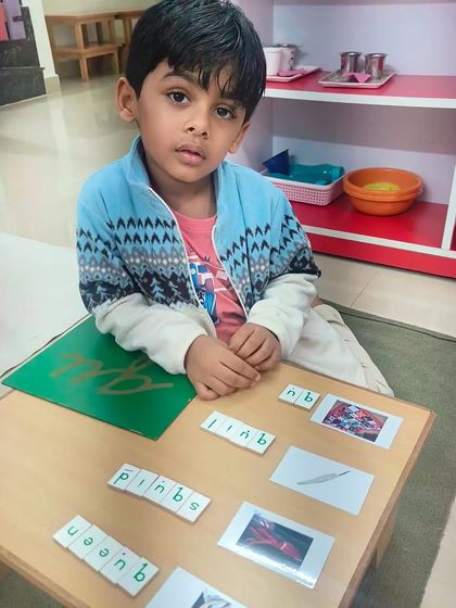 This child is using picture cards and the movable alphabet to practice spelling. This hands-on process makes learning to read and write an engaging activity rather than a tedious chore.