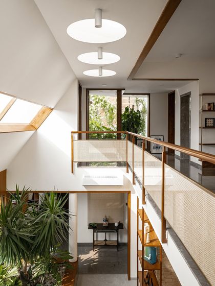 An elevated perspective of the double-height living space, showcasing the interplay of skylights, windows, and indoor plants. This architectural approach is central to creating my signature tropical modern style.