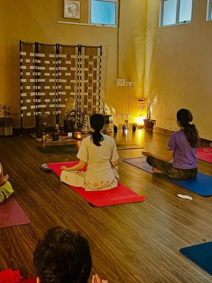 A moment of quiet meditation in the warm, candlelit glow of the shala. This is a time for introspection and connecting with the self.