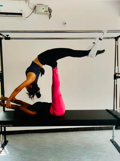 Duet sessions are a fantastic way to stay motivated. Here, we're working together on the Cadillac to achieve a challenging partner pose that requires trust and synchronization.
