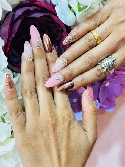 This view showcases the full set against a floral background, highlighting the combination of matte, chrome, glitter, and rhinestone elements.