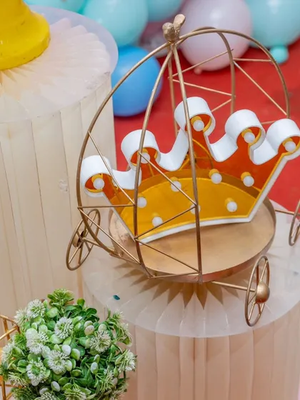 A detail shot of the golden crown carriage prop, a perfect little touch for any princess or butterfly-themed party.