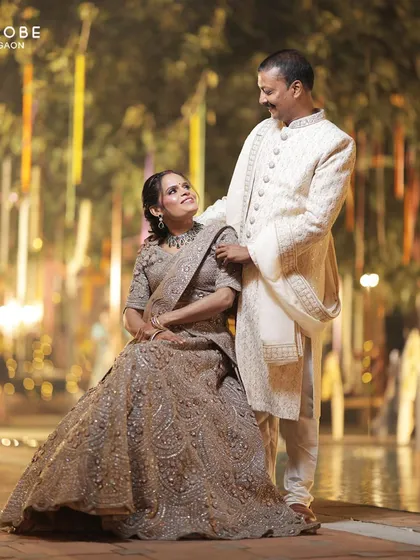 A beautiful, candid moment between the couple, showcasing their stunning coordinated ethnic wear against a backdrop of fairy lights.
