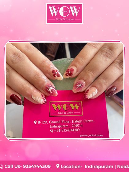 A festive and artistic design on almond-shaped extensions. This set combines deep red with a neutral base, featuring hand-painted floral and starburst patterns for a unique holiday look.