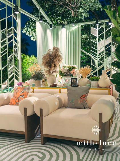 The lounge area of 'The Conservatory' glows at night, with the custom wallpaper and furniture creating a sophisticated and cozy atmosphere.