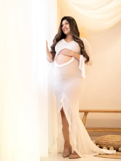A confident and glowing portrait of the mom-to-be, looking radiant in this form-fitting white gown.