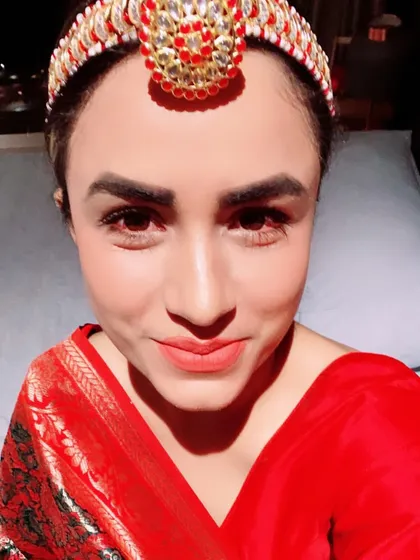 Accessories can define an ethnic look. This close-up shows how a traditional matha patti headpiece can elevate a simple red saree, making it suitable for a bridal event or a major festival.
