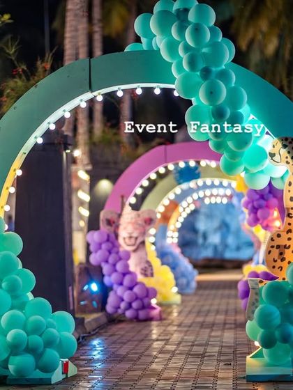 The magical "Party Animal" entrance tunnel at night, lit up with string lights to create an enchanting pathway for guests.
