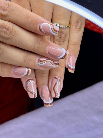 Summer swirls in warm tones. A beautiful set of extensions with abstract swirls in shades of brown, white, and gold.