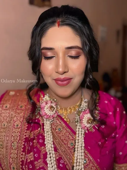 A close-up of the baby shower makeup, showing the soft pink eyeshadow and the floral jewelry.