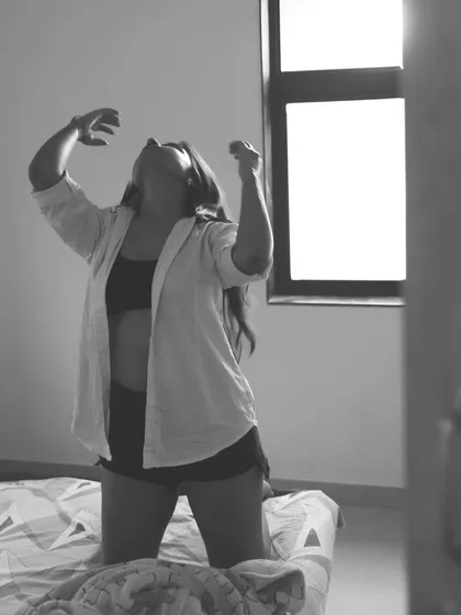 An expressive and emotional black and white shot, using the window light to create a powerful, dramatic scene.