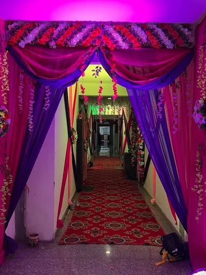 An entrance to a hallway decorated with a beautiful arch of pink and purple drapes.