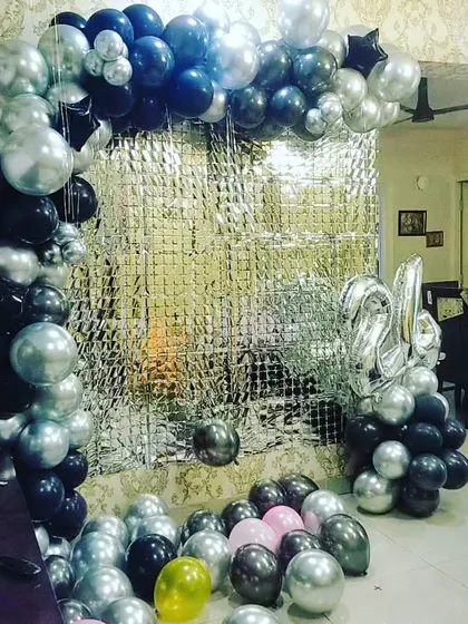 Another photo of the black and silver birthday balloon arch, providing a clear view of the full setup with the foil curtain and number balloons.