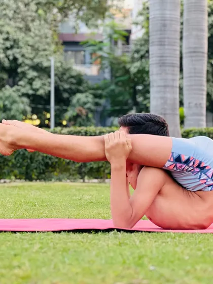 This reclining leg-behind-head pose is a deep hip opener. It might look playful, but it's the result of serious practice.