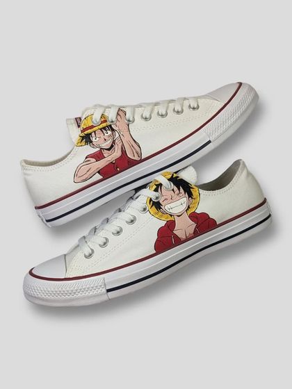 A full view of the Luffy Converse kicks. I painted a different cheerful expression on each shoe, capturing the future King of the Pirates' infectious energy.