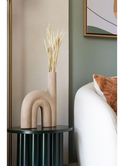 A close-up of the unique U-shaped vase, which adds an artistic and modern touch to the living space.