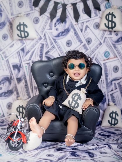 The boss is in, and he's got his shades on. This shot captures the ultimate cool-kid vibe in the "Boss Baby" setup, complete with a mini motorcycle and bags of money.