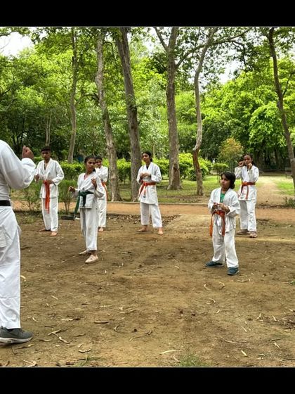 I always lead by example. Here, I am guiding my students through their forms during an outdoor belt test in the park.
