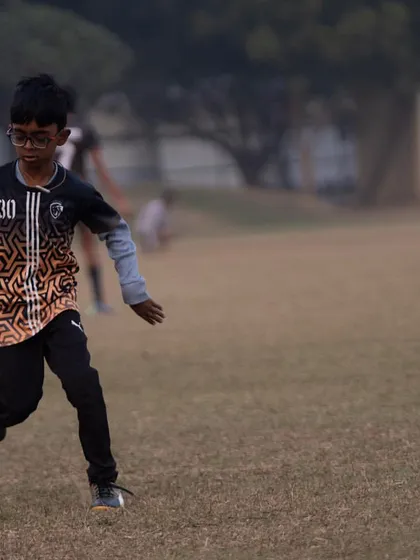 A young player dribbling the ball, focused and determined.